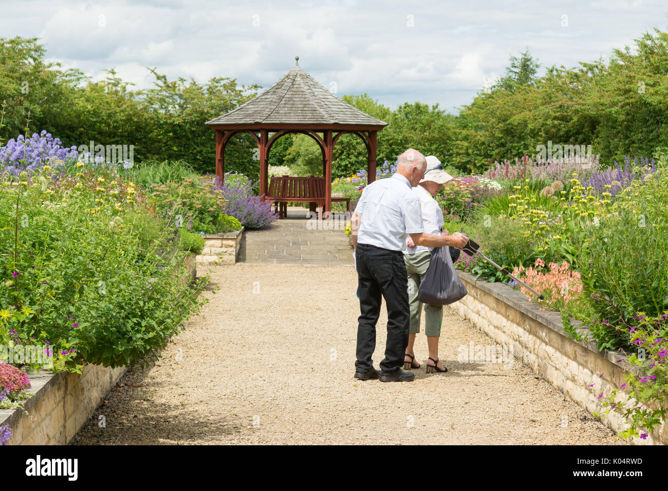 Couple de personnes âgées se rendant sur Breezy genoux jardins, York, England, UK Banque D'Images