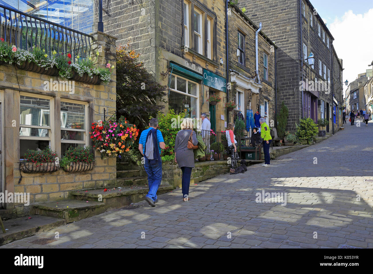 Les visiteurs jusqu'à pied de la rue principale pavée, Haworth, West Yorkshire, Angleterre, Royaume-Uni. Banque D'Images