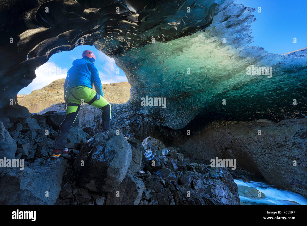 Le parc national de Skaftafell, l'Islande, l'Europe. L'homme admire le cristal bleu caverne de glace sous le glacier de Vatnajokull en hiver. Banque D'Images