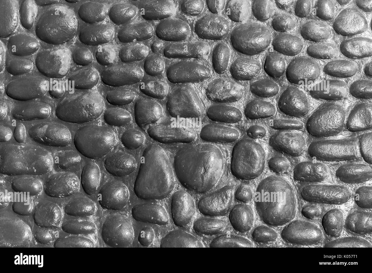 Gros plan mur construction main river pierres rondes libre abstraite noir et blanc décoration de fond à l'extérieur. Banque D'Images