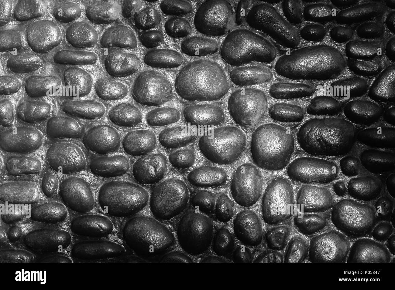 Gros plan mur construction pierres rondes de la rivière Main libre noir blanc décoration fond abstrait à l'extérieur. Banque D'Images