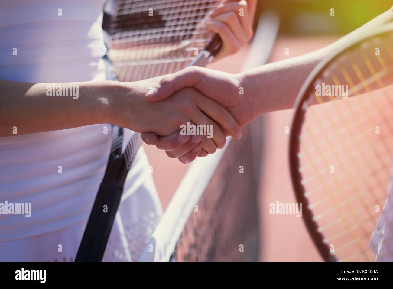 Close up les joueurs de tennis handshaking in esprit sportif au filet Banque D'Images