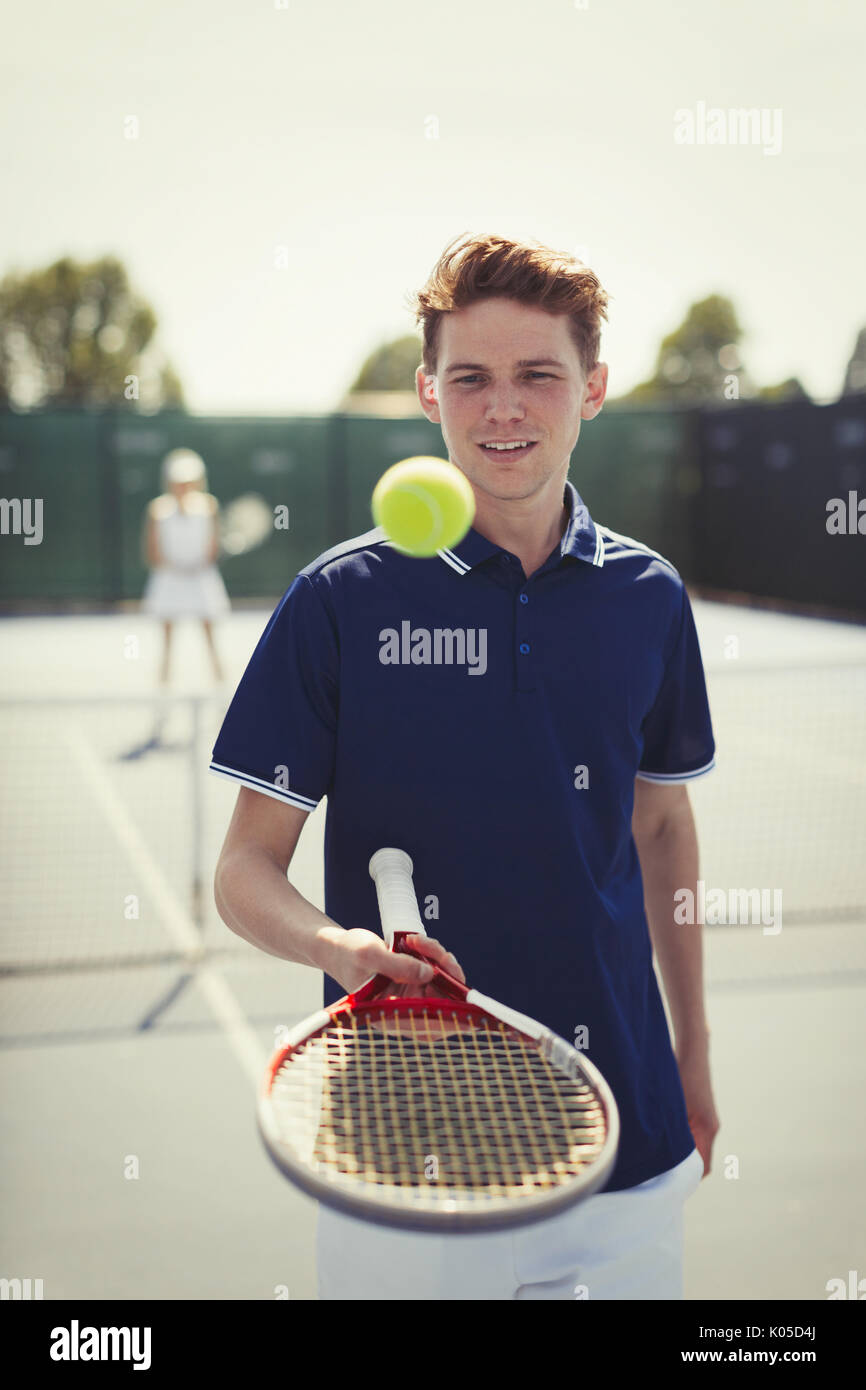 Jeune joueur de tennis masculin balle de tennis qui rebondit sur la raquette de tennis sur le court de tennis Banque D'Images