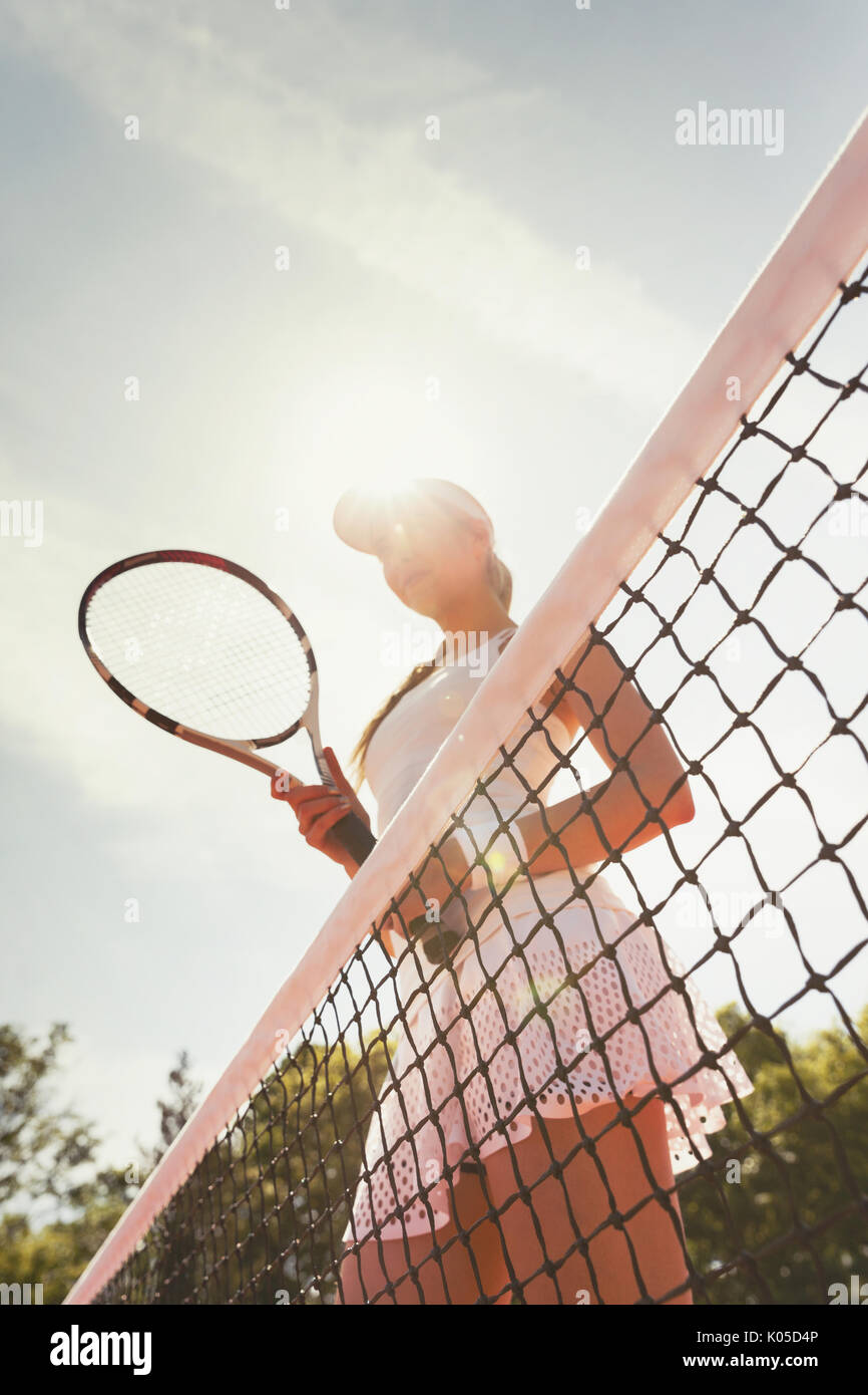 L'accent tennis player avec raquette de tennis sur net à court de tennis ensoleillé Banque D'Images