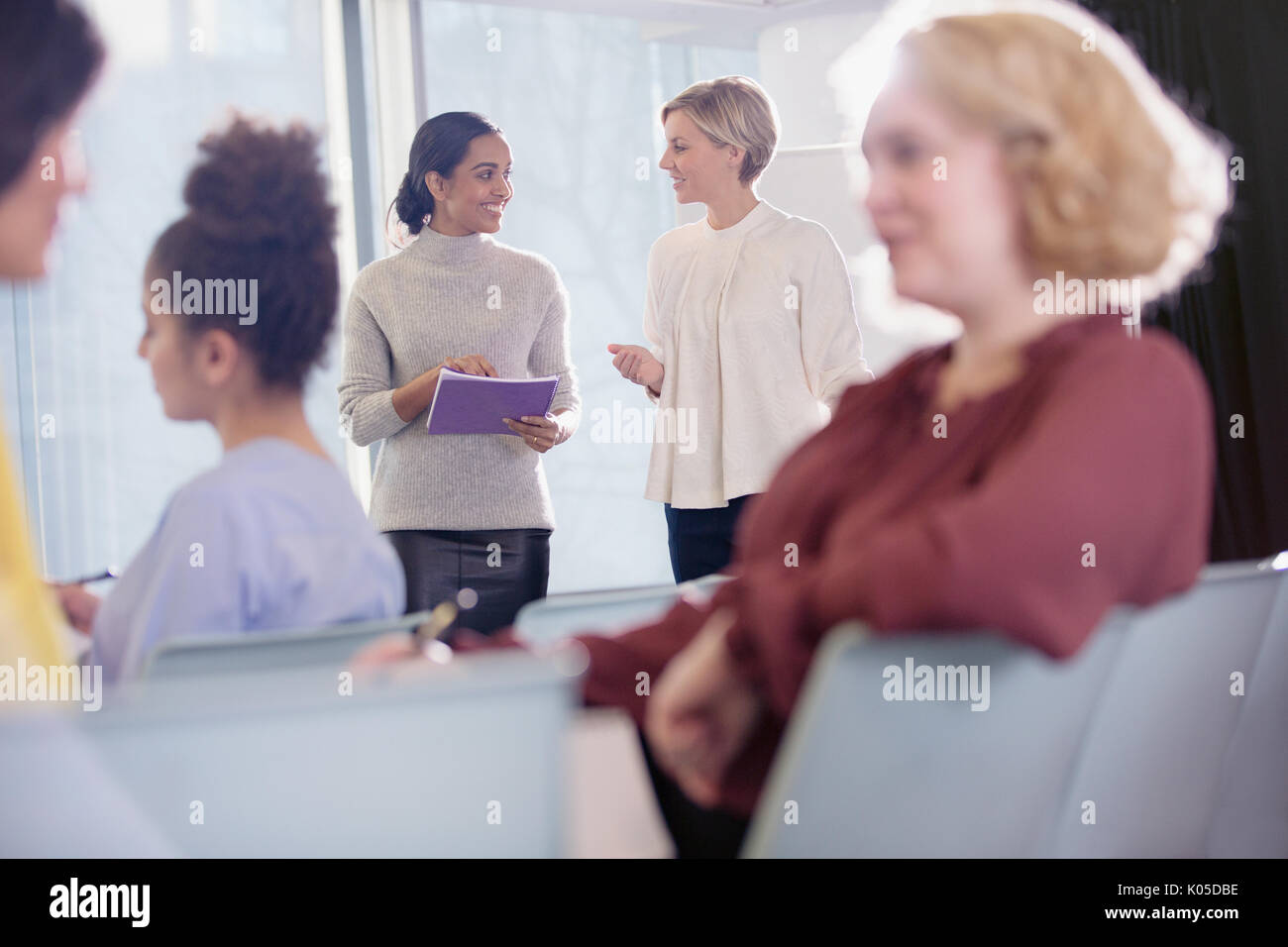 Businesswomen talking in conference audience Banque D'Images