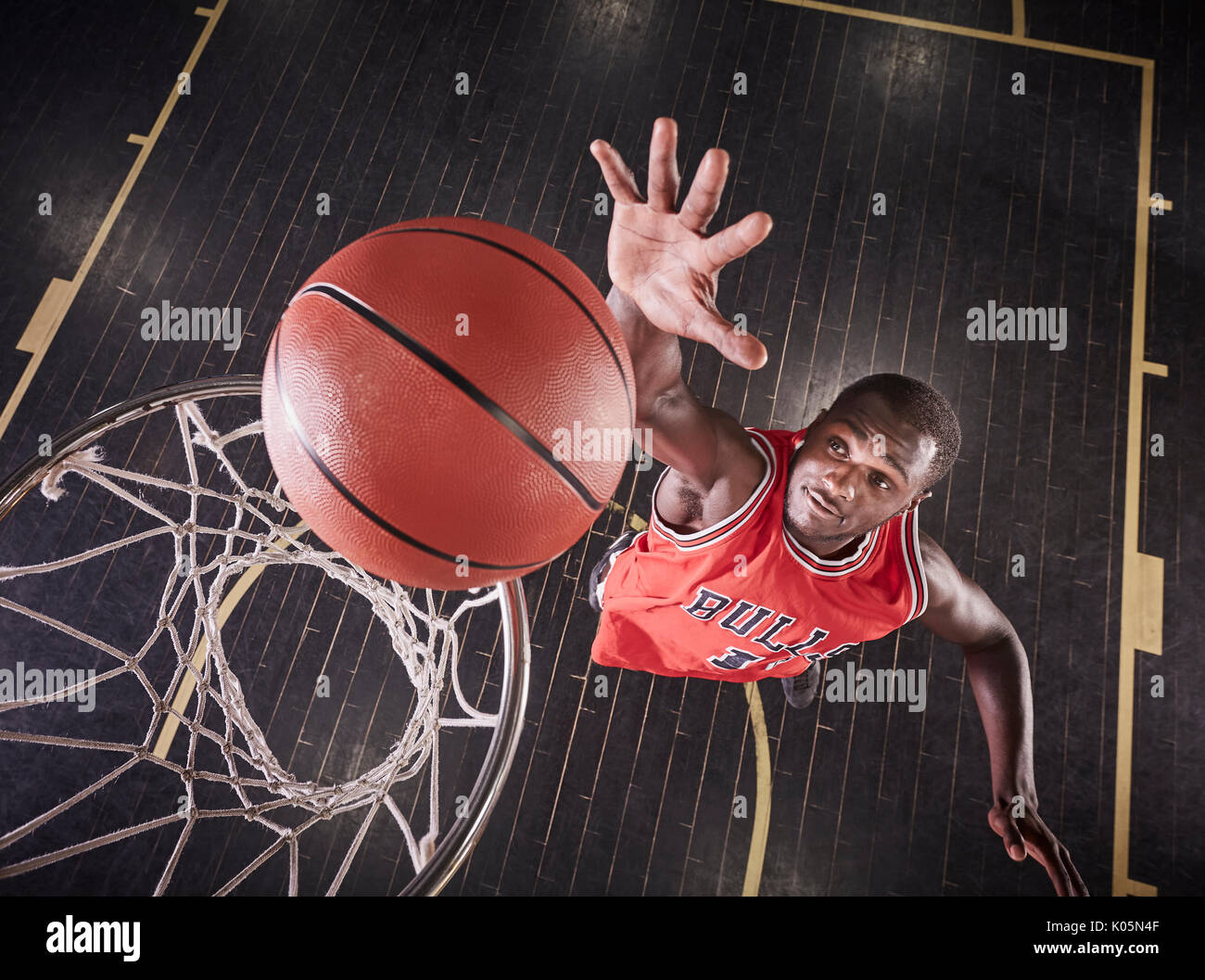 Vue aérienne du jeune joueur de basket-ball masculin de sauter à rebondir la balle sur la jante de basket-ball Banque D'Images