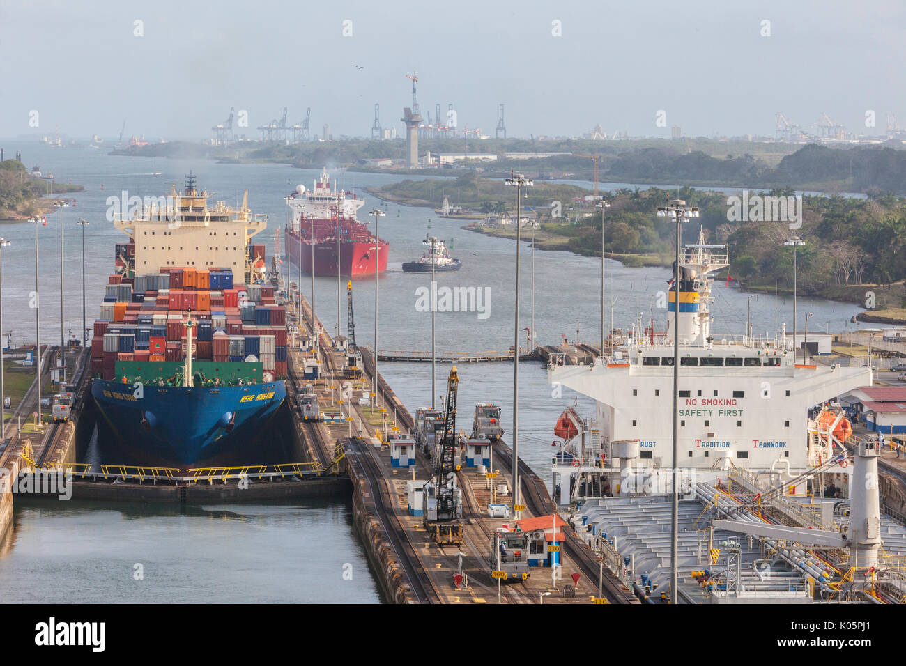 Canal de Panama, Panama. Deux navires entrant dans Première écluse en direction du sud, des Caraïbes en ce qui concerne l'arrière. Troisième navire vous attend son tour. Colon grues portuaires en remontant jusqu'à Banque D'Images