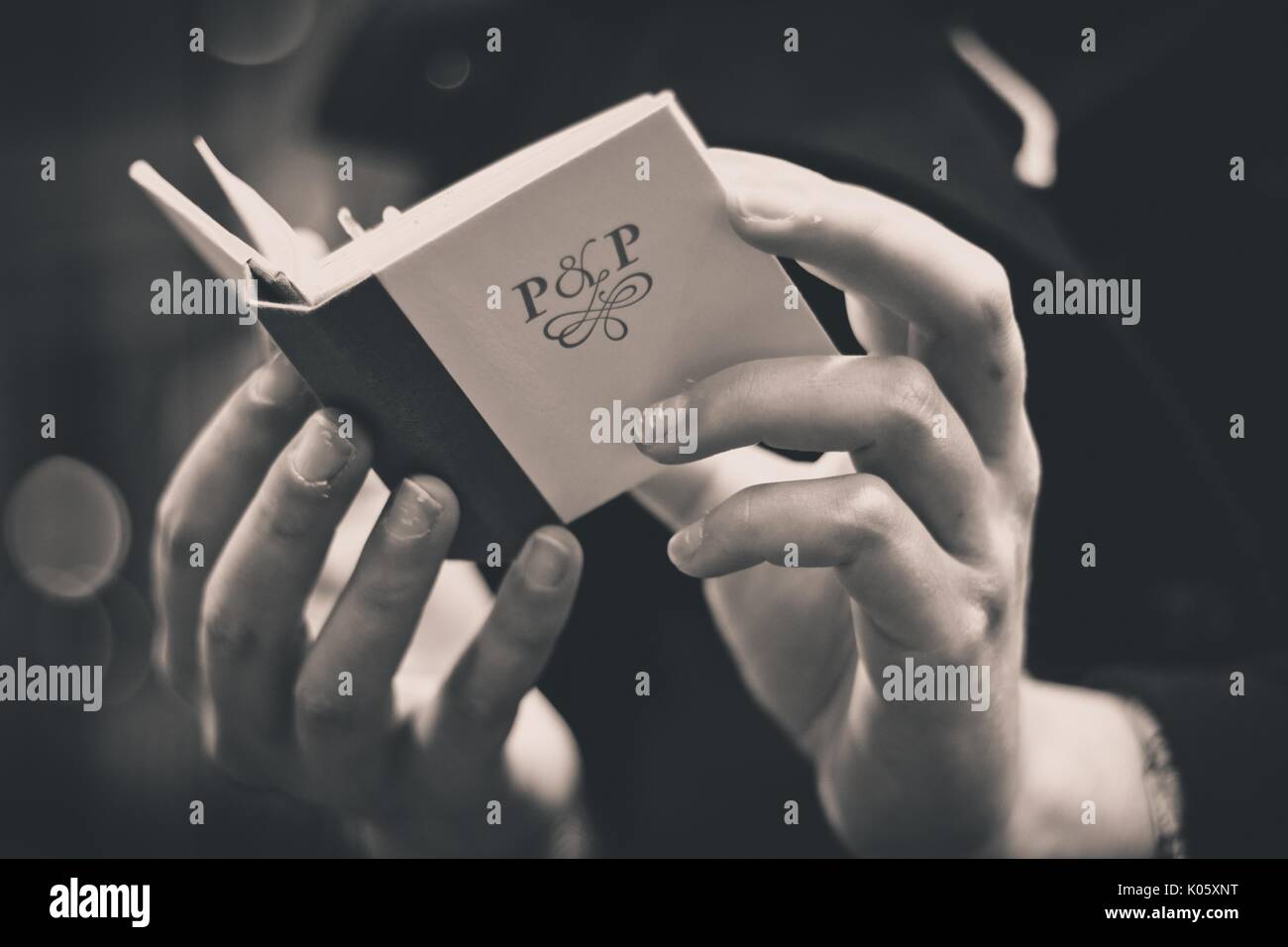 Close up de la main d'un college student holding et la lecture d'un mini-livre dans le département des collections spéciales de la bibliothèque universitaire, le livre intitulé 'P et P', pour l'Orgueil et préjugés, 2016. Banque D'Images