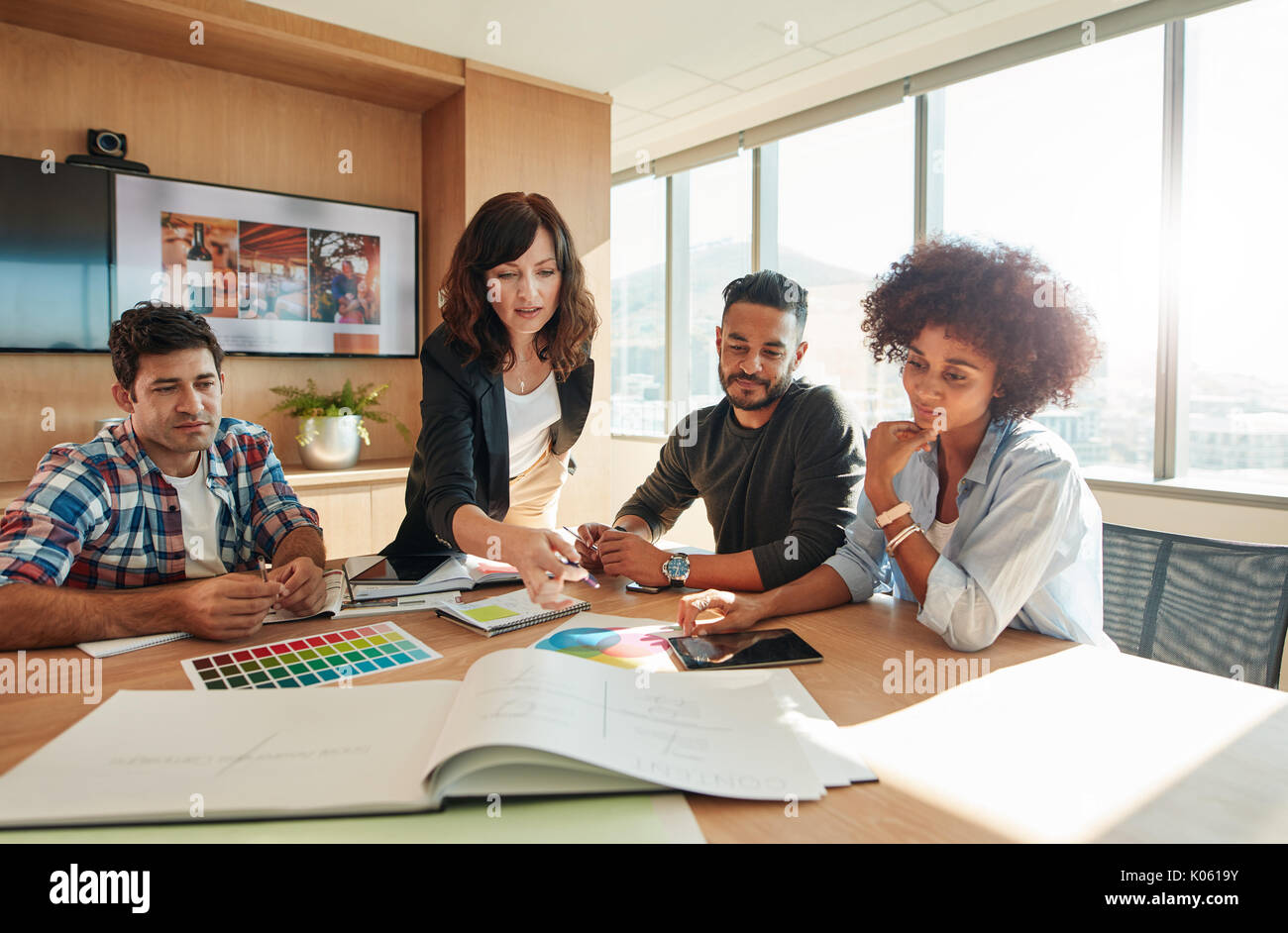 Les gens créatifs à projet au plan établi sur la table. Mixed Race associés discutent de nouvelles plan de projet dans un bureau moderne. Banque D'Images