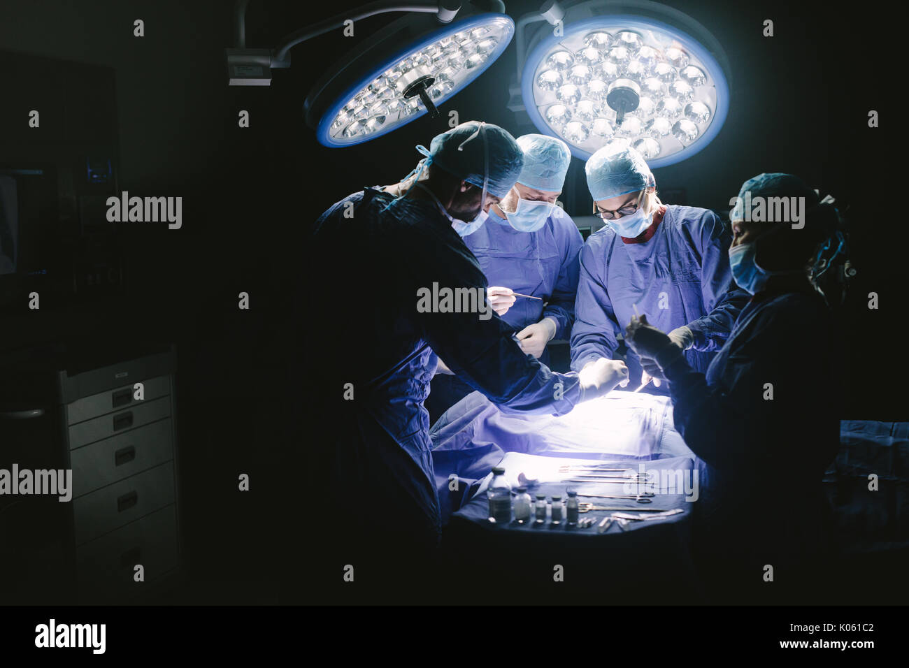 Les médecins au cours de l'intervention de l'état du patient à l'hôpital. L'équipe de chirurgiens travaillant à l'hôpital d'effectuer une procédure chirurgicale en salle d'opération. Banque D'Images