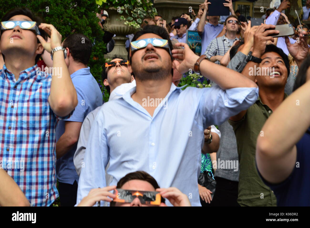 Une foule de New-Yorkais enfilent leurs lunettes solaires pour voir en toute sécurité l'éclipse solaire à Bryant Park à Manhattan Banque D'Images