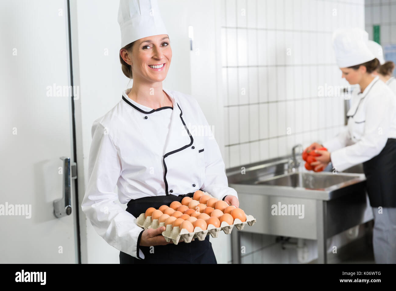 Chef en cuisine de cantine en tenant les oeufs hors de l'entrepôt frigorifique Banque D'Images