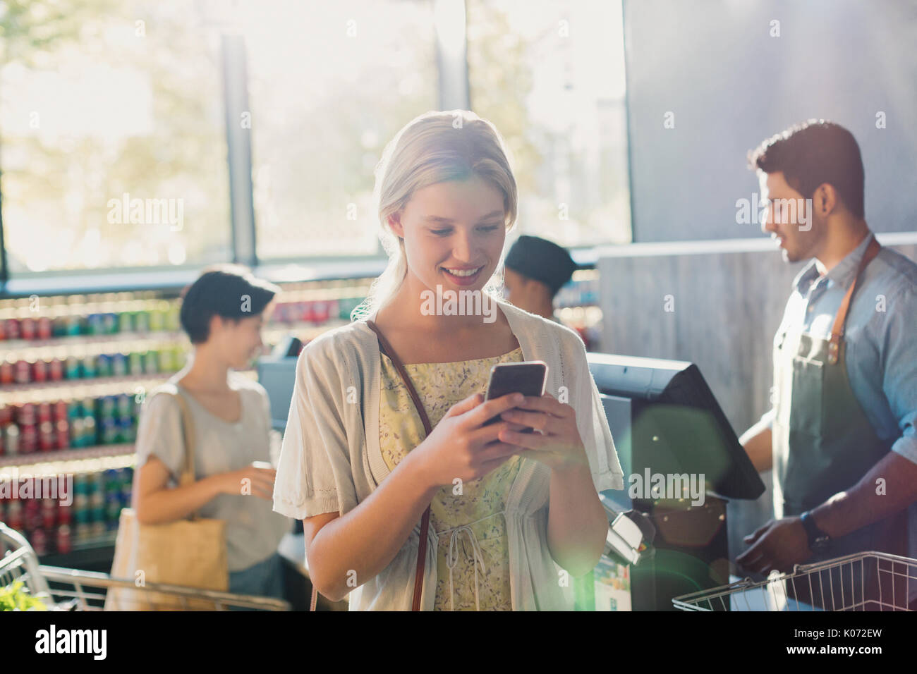 Young woman using cell phone in market Banque D'Images