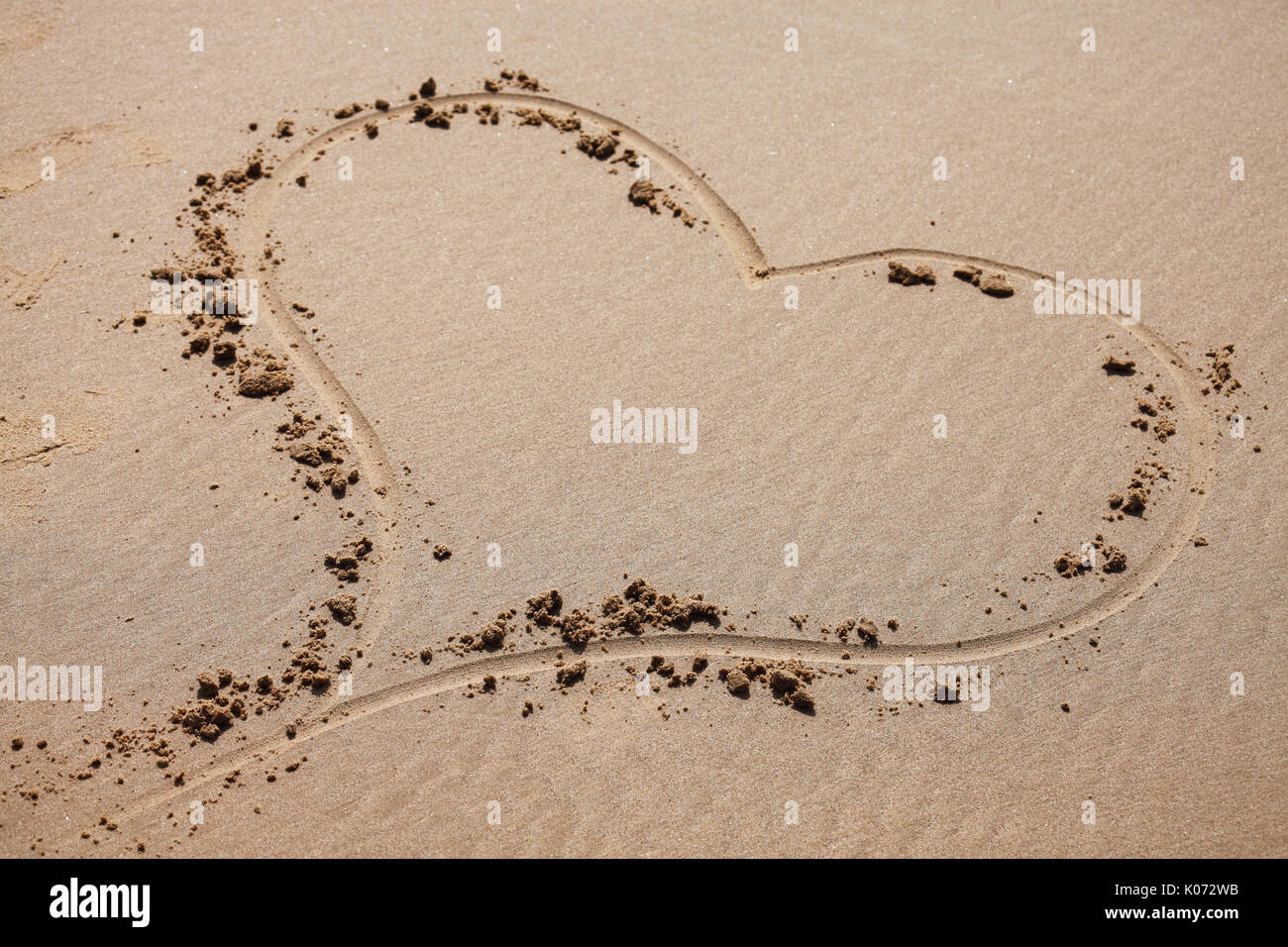 Coeur d'amour dans le sable sur une plage. Banque D'Images