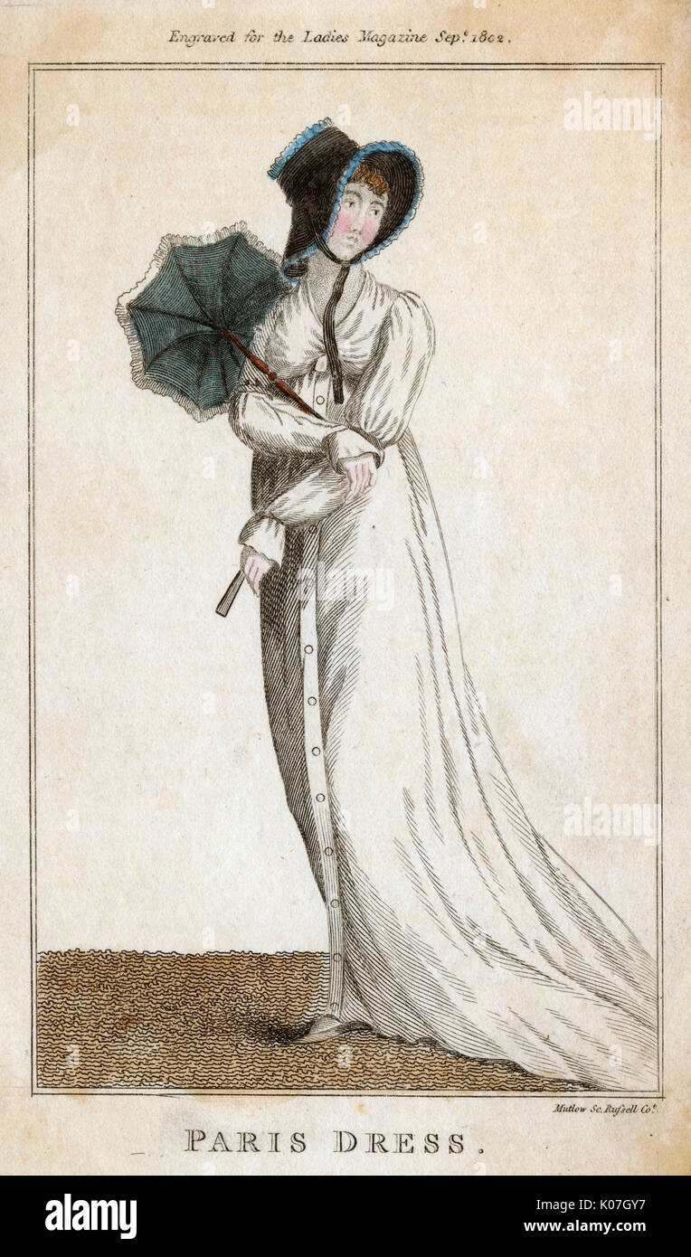 Une dame est titulaire d'un petit parasol avec un bâton sculpté avec  élégance. Cela pourrait être un ventilateur parasol avec un couvercle à  charnière qui pourrait être incliné verticalement et utilisé comme
