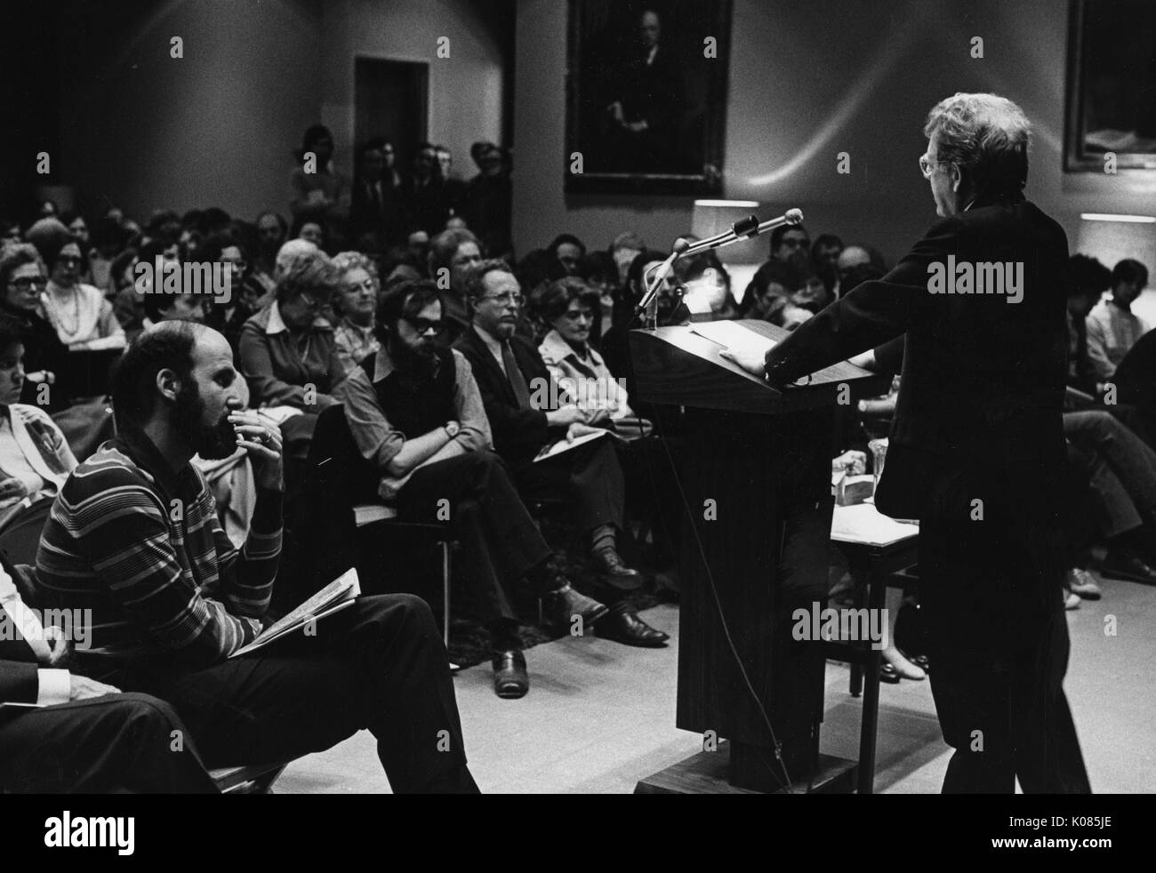 Auteur Northrup Frye donnant un discours, portant un costume sombre et des lunettes, debout derrière un podium en bois, les deux mains appuyé sur le podium, l'auditoire avec toutes les expressions du visage grave, 1972. Banque D'Images