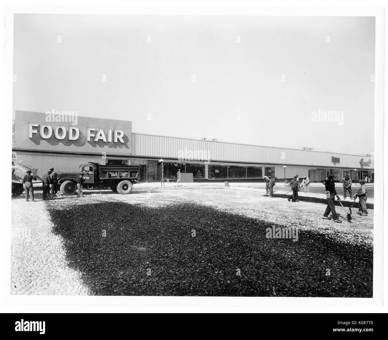 Surfaceworkers herbeux travaillant sur le nettoyage de la substance blanche sur l'herbe, debout devant stocker xcalled «fome biens', Baltimore, Maryland, 1930. Banque D'Images