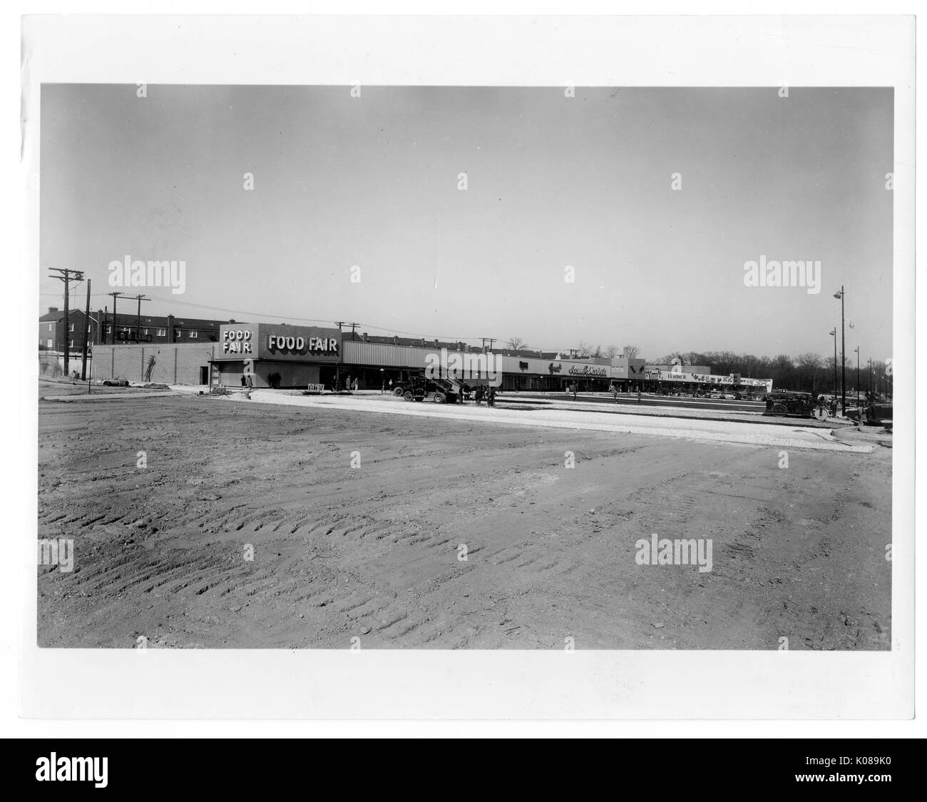 Photographie de la place de l'aire de stationnement pour le centre commercial Northwood à Baltimore, Maryland, avec les bâtiments commerciaux tels que salon de l'alimentation, les bâtiments résidentiels, et arbres en arrière-plan, Baltimore, Maryland, 1950. Banque D'Images
