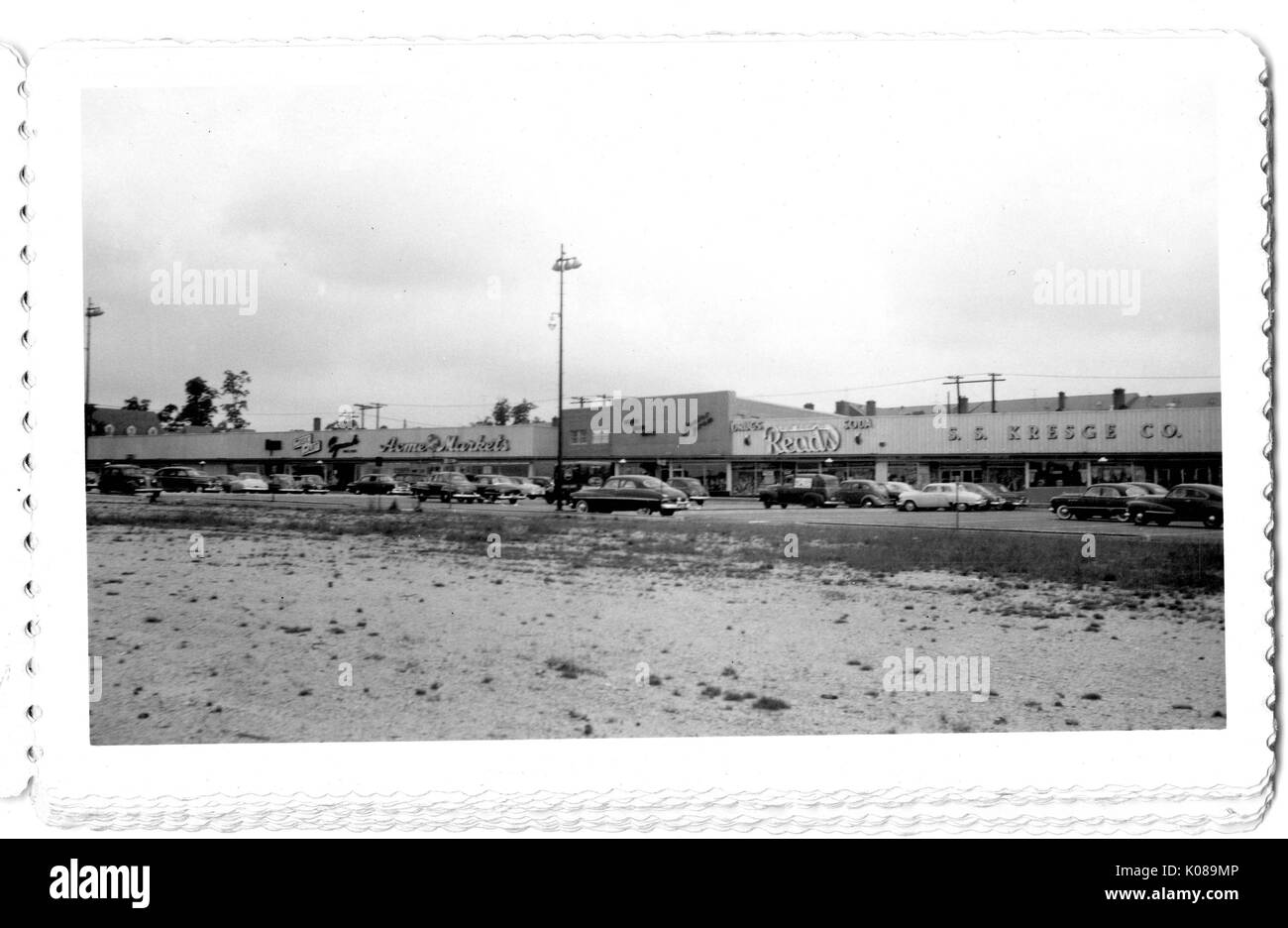 Photographie de voitures garées en face de bâtiments commerciaux dans le centre commercial Northwood, comme S S Kresge Company, Baltimore, Maryland, 1940. Banque D'Images