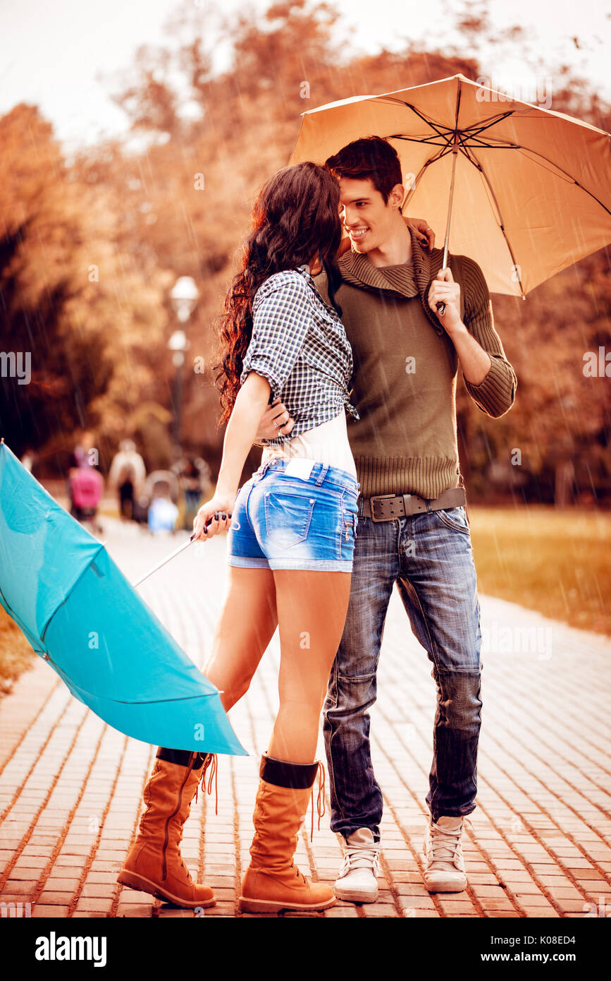Beau beau couple et danse avec parasols dans le parc en couleurs de l'automne. Banque D'Images