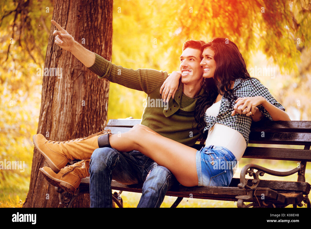 Belle lovely couple assis sur le banc et profiter à sunny park en couleurs de l'automne. Banque D'Images