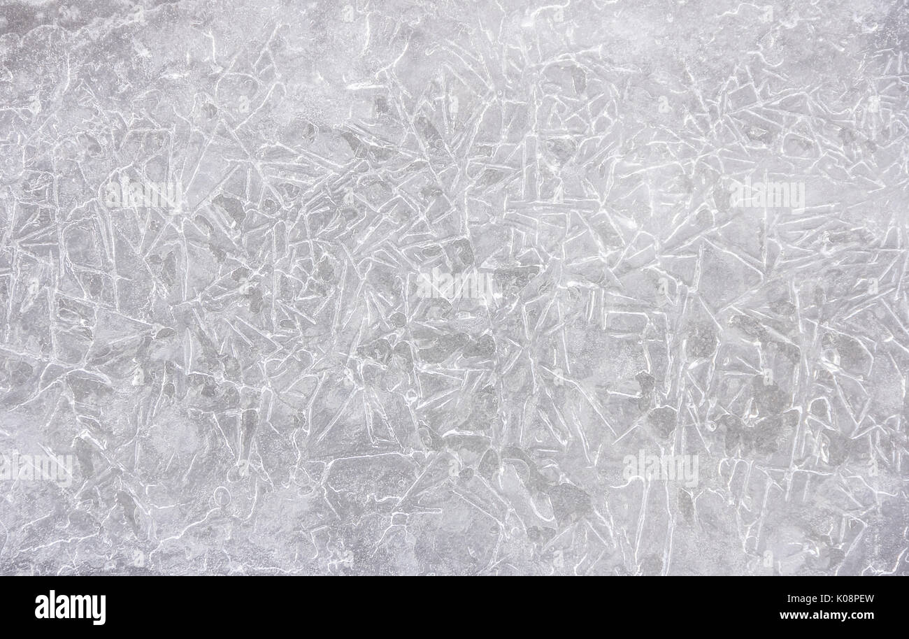 La texture de la glace sur un lac d'eau en hiver à l'extérieur avec de la neige Banque D'Images