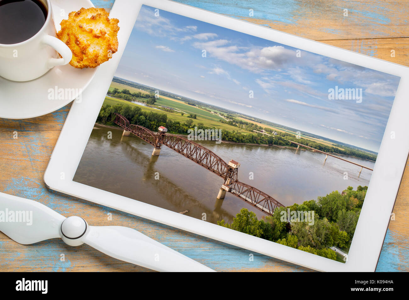 Chemin de fer historique Katy Pont sur la rivière Missouri à Boonville - examen de l'image aérienne sur une tablette numérique avec une tasse de café Banque D'Images