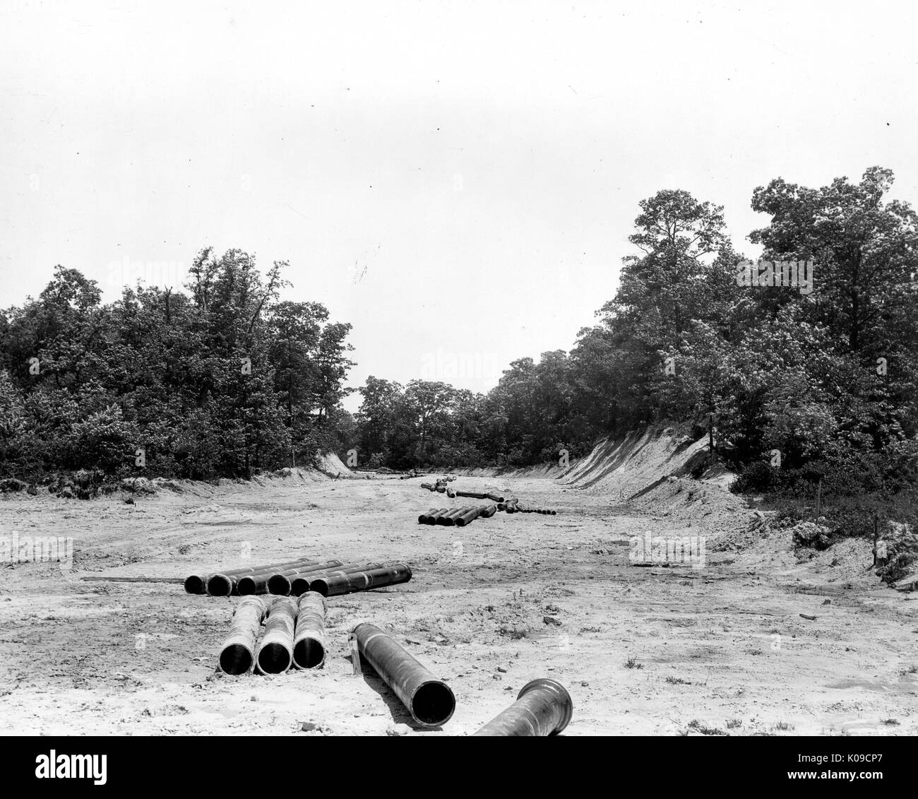 Northwood Neighbourhood land en construction, il y a des larges tuyaux éparpillés sur la saleté, il y a des arbres et arbustes dans l'arrière-plan qui sont riverains de la terre, United States, 1950. Banque D'Images