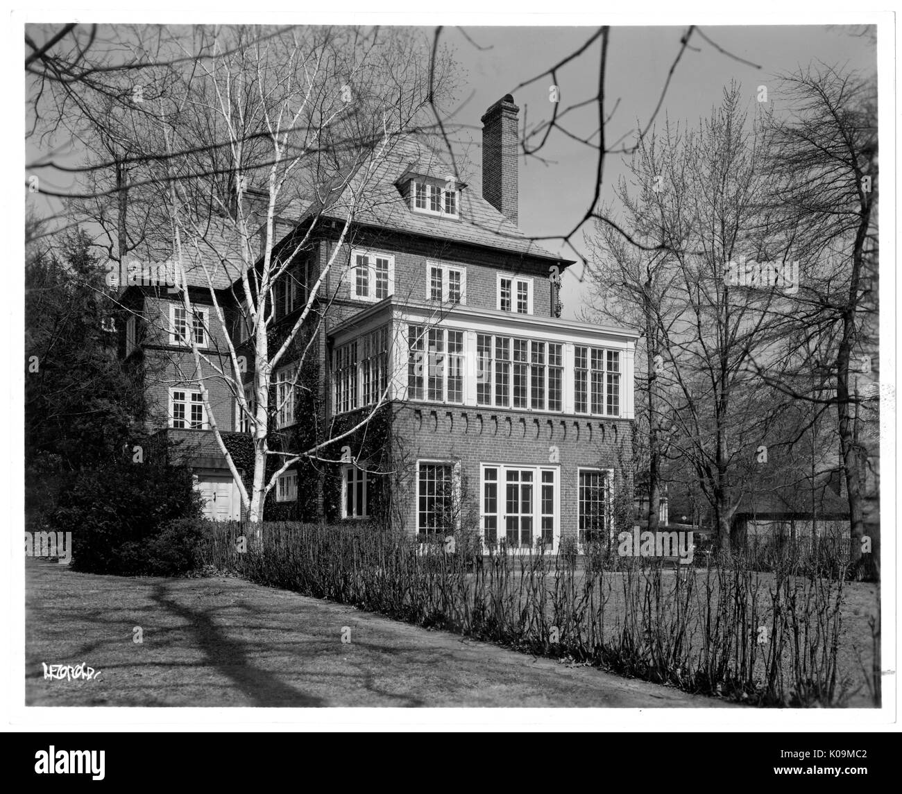 Photo de paysage de l'arrière d'une grande maison de trois étages avec de grandes fenêtres, un grand jardin gazonné, et d'arbustes sans feuilles entourant l'arrière-cour, Roland Park/Guilford, Baltimore, Maryland, 1910. Cette image est tirée d'une série sur la construction et la vente de maisons dans le quartier Roland Park/Guilford de Baltimore, a streetcar suburb et l'une des premières communautés planifiées aux États-Unis. Le quartier a été isolé, et est considéré comme l'un des premiers exemples de l'application de la ségrégation raciale par l'utilisation d'alliances. Banque D'Images