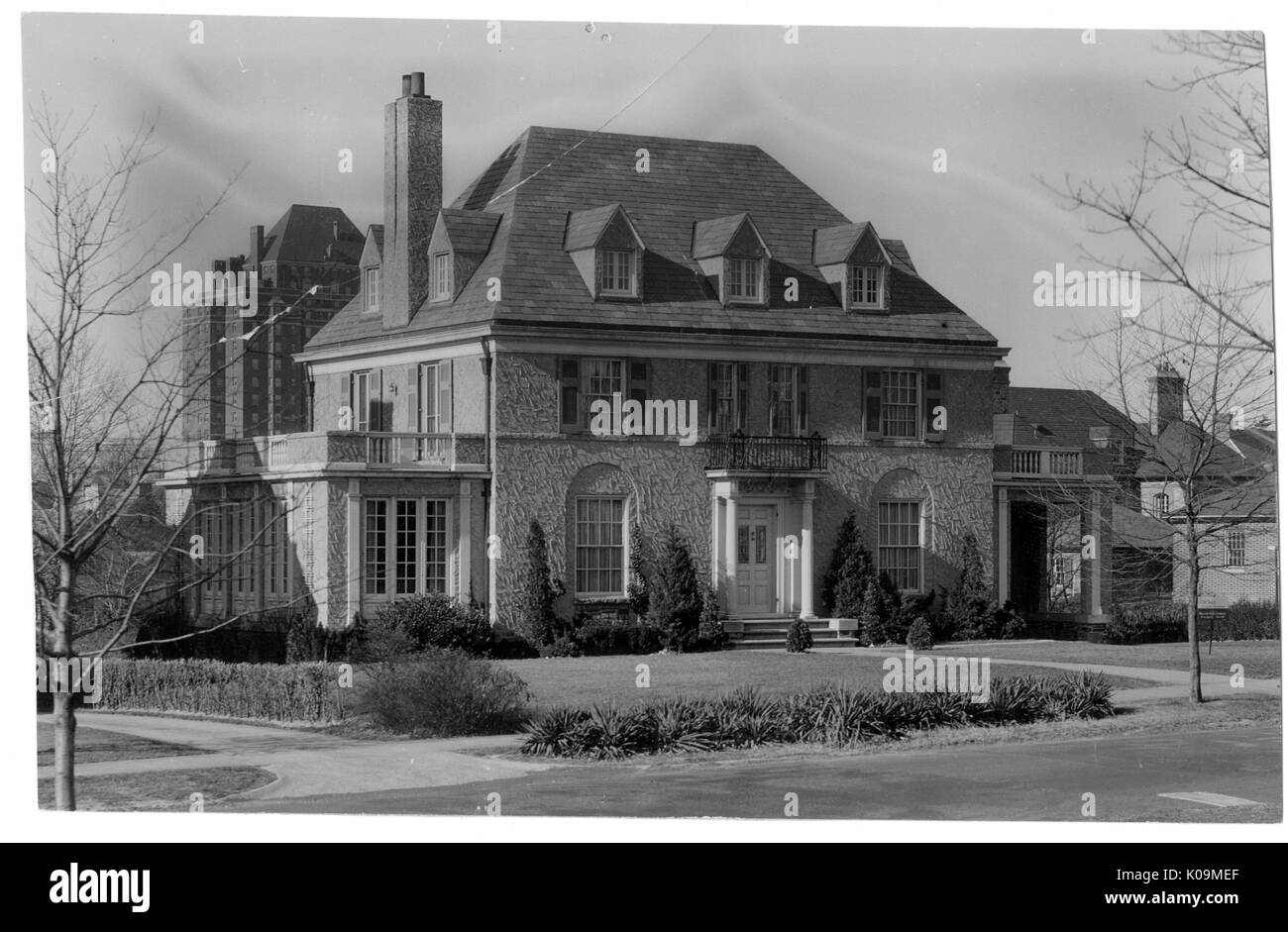 Photo de paysage d'une grande maison de trois étages avec une texture avant, deux cheminées, les arbustes bien gardé en face de la maison, arbres sans feuilles en face de la maison, Roland Park/Guilford, Baltimore, Maryland, 1910. Cette image est tirée d'une série sur la construction et la vente de maisons dans le quartier Roland Park/Guilford de Baltimore, a streetcar suburb et l'une des premières communautés planifiées aux États-Unis. Le quartier a été isolé, et est considéré comme l'un des premiers exemples de l'application de la ségrégation raciale par l'utilisation d'alliances. Banque D'Images