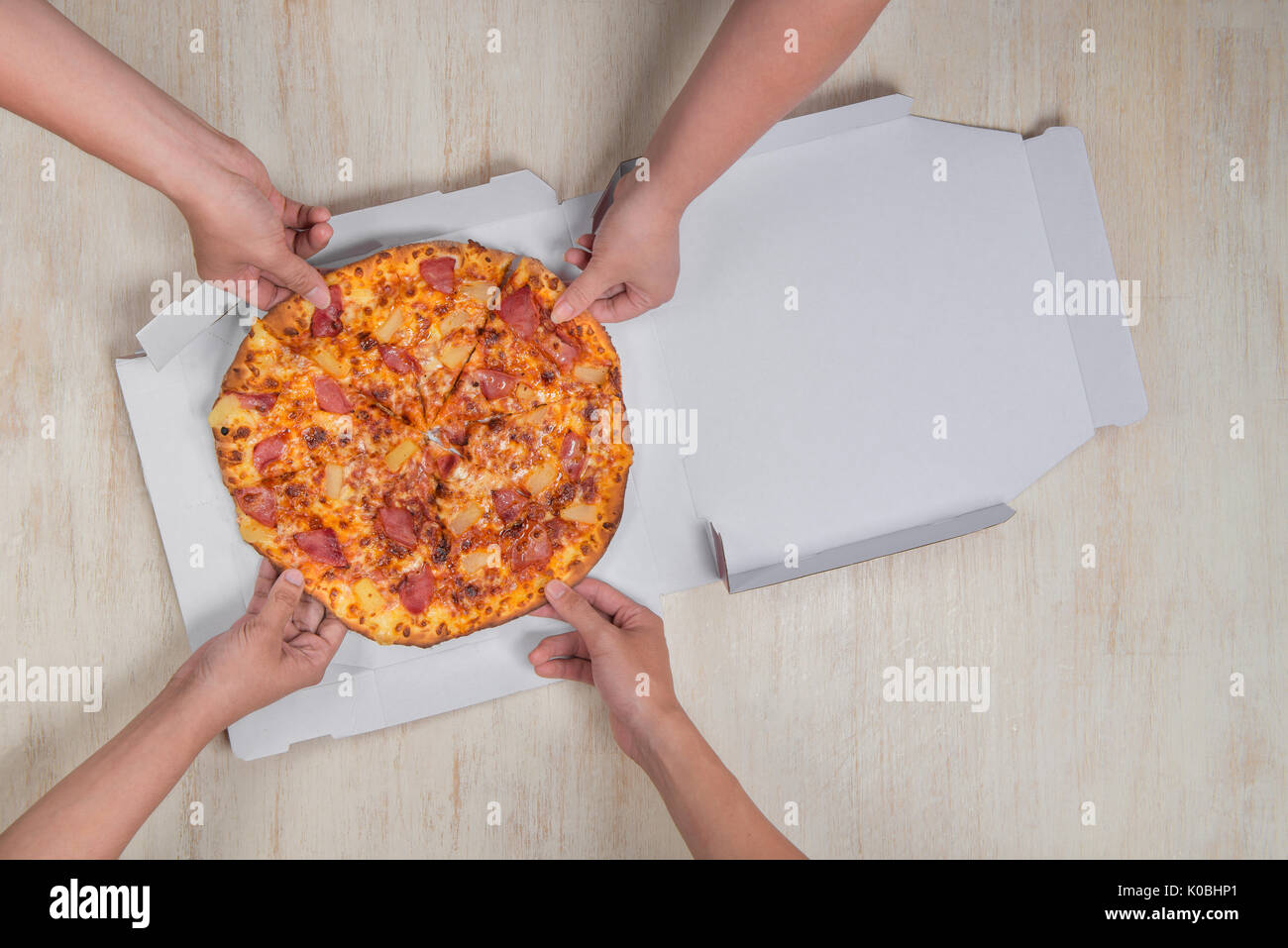 Heureux les gens assis autour de la table en train de manger le déjeuner au bureau en coworking pendant les pauses Banque D'Images