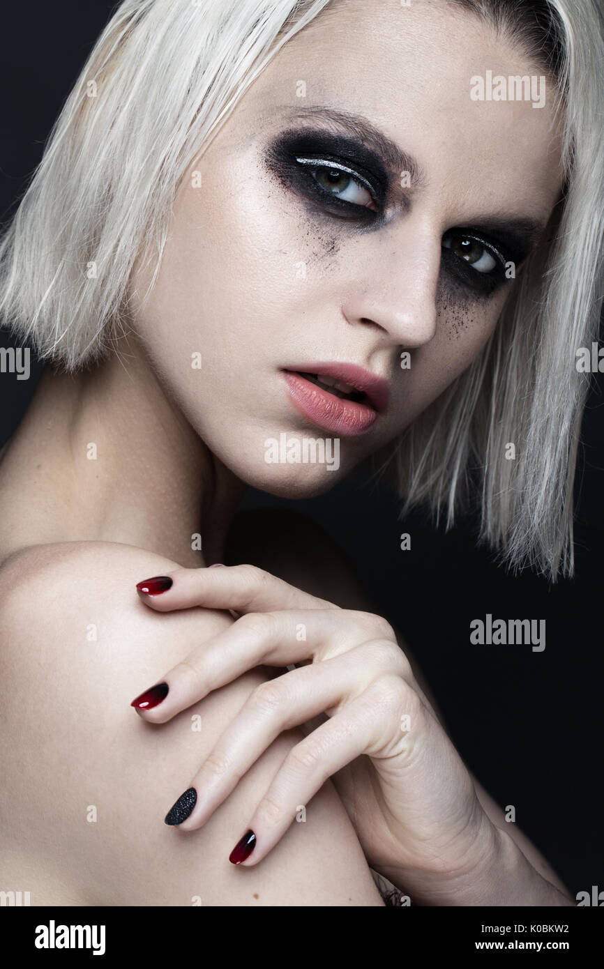 Belle fille blonde avec smokey foncé et maquillage manucure ongles art design. beauté visage. Banque D'Images