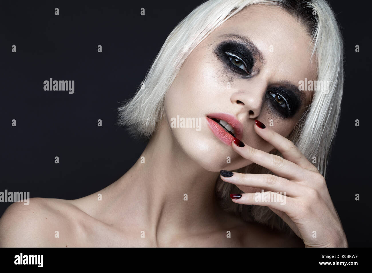 Belle fille blonde avec smokey foncé et maquillage manucure ongles art design. beauté visage. Banque D'Images