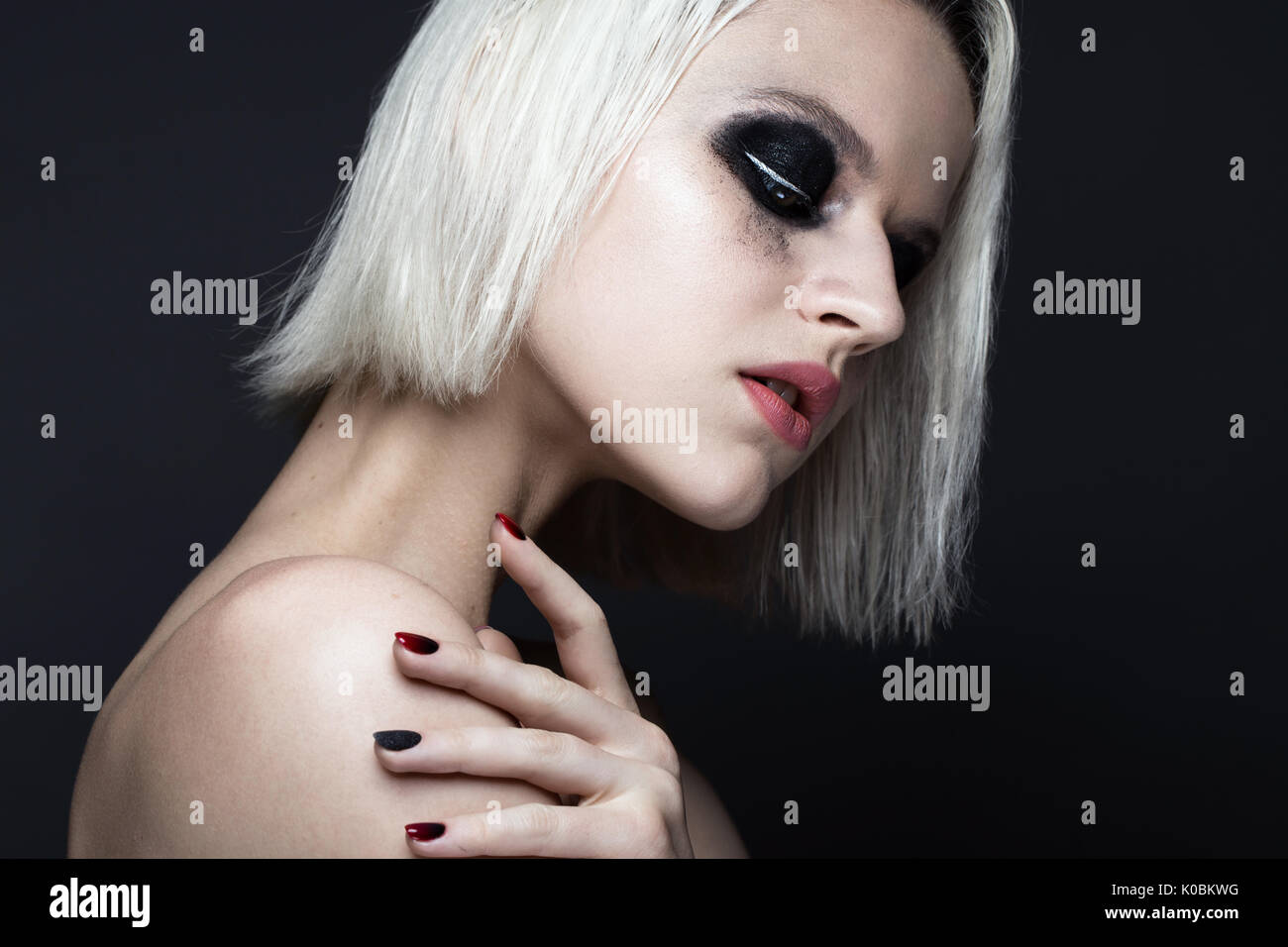 Belle fille blonde avec smokey foncé et maquillage manucure ongles art design. beauté visage. Banque D'Images