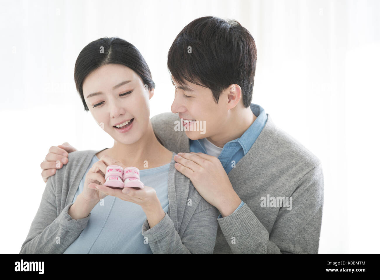 Portrait of pregnant couple harmonieux avec fournitures pour bébés Banque D'Images