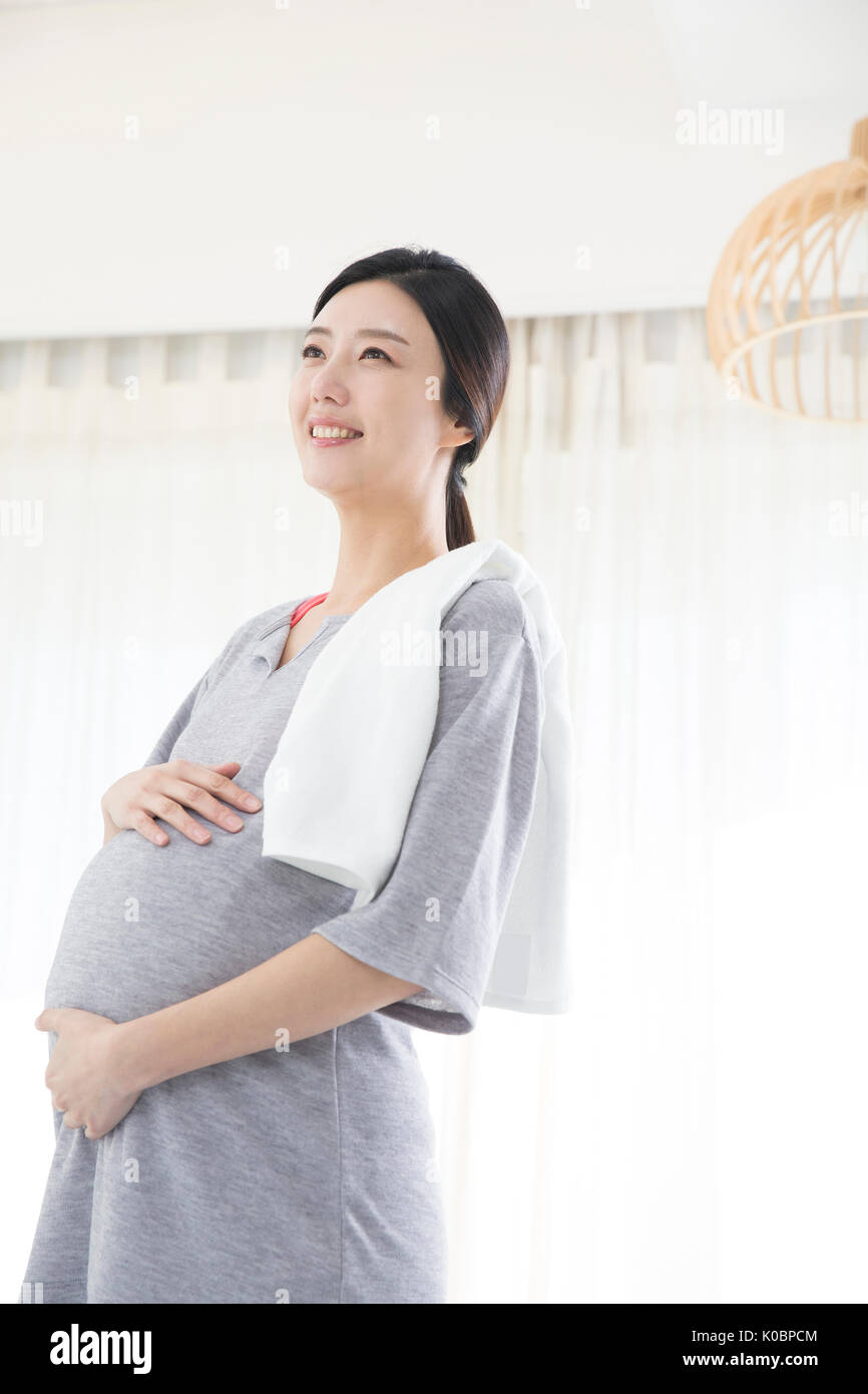 Smiling pregnant woman in sweatsuit Banque D'Images