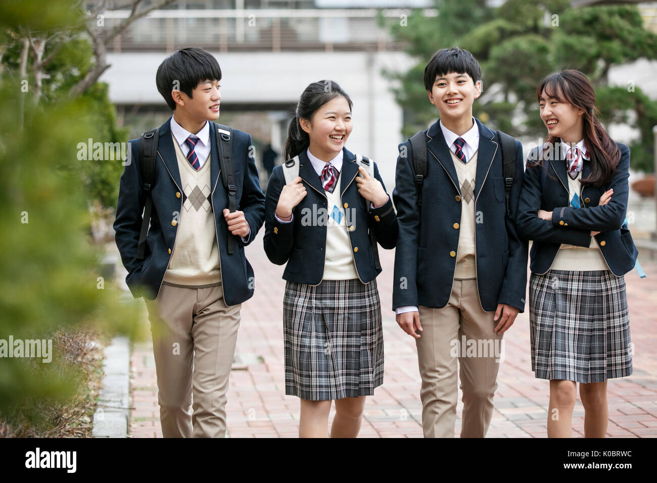 Quatre étudiants de l'école smiling walking Banque D'Images