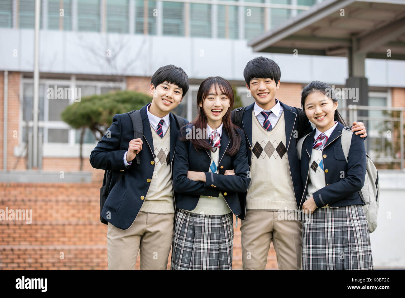 Quatre étudiants de l'école sourire posant à l'école Banque D'Images