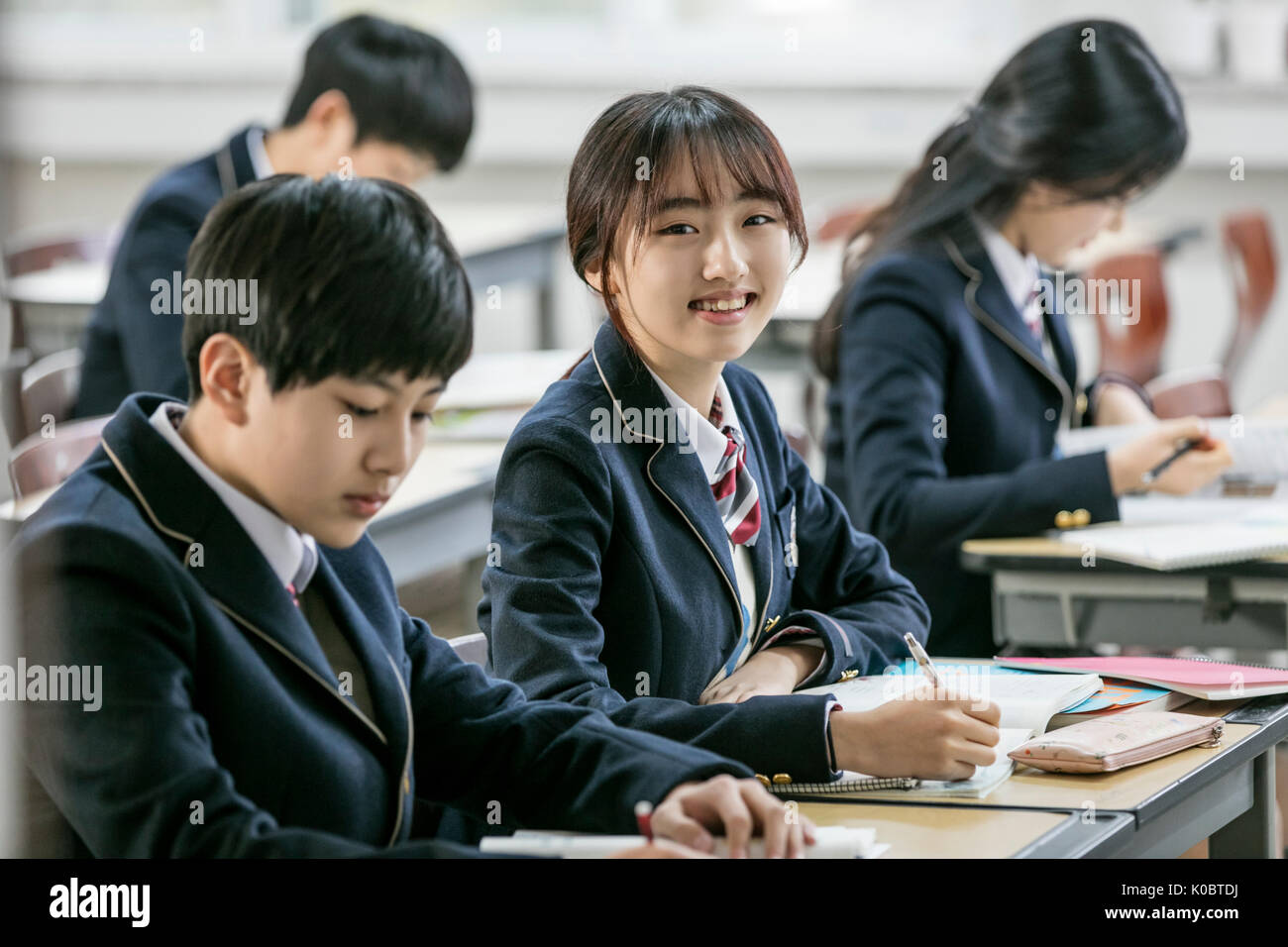 Smiling school girl et ses camarades de classe en tenant Banque D'Images