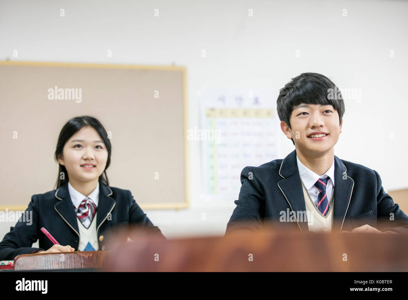 Pf Portrait smiling school boy et school girl in classroom Banque D'Images