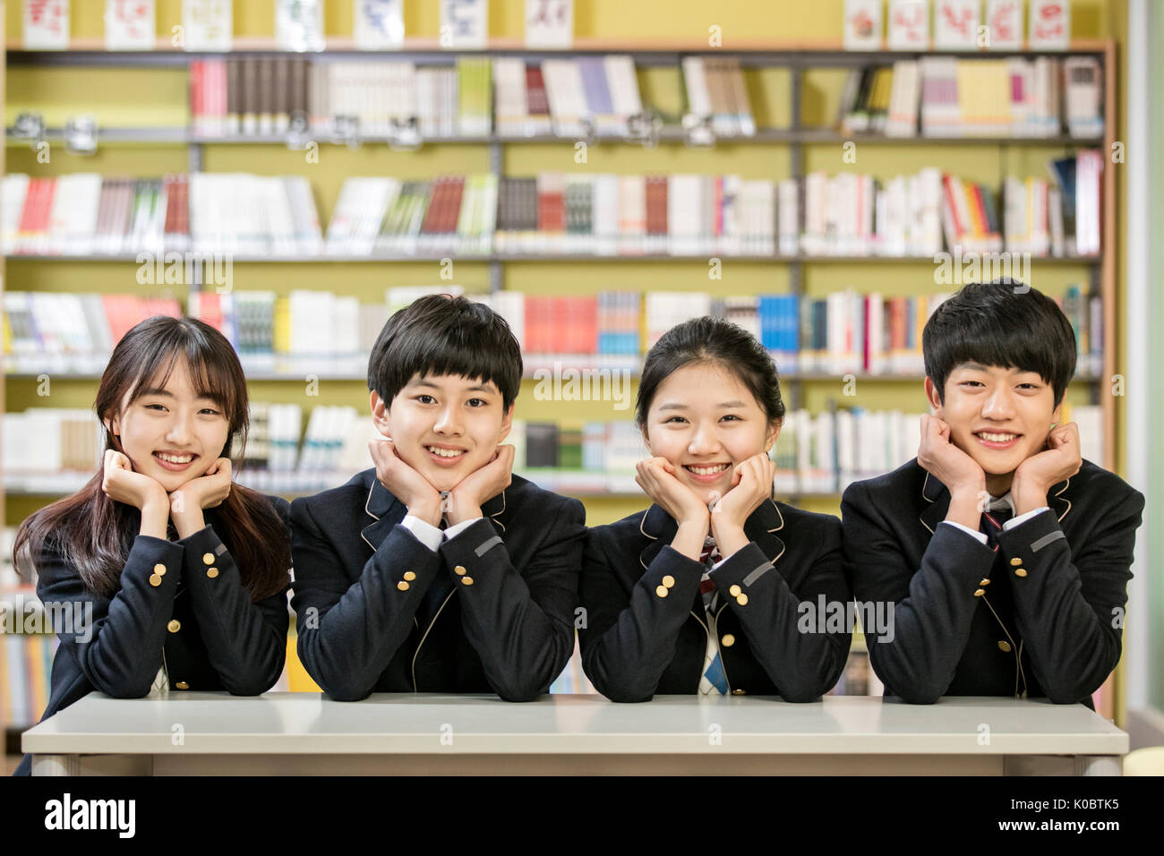 Portrait de quatre étudiants de l'école sourire posing in library Banque D'Images