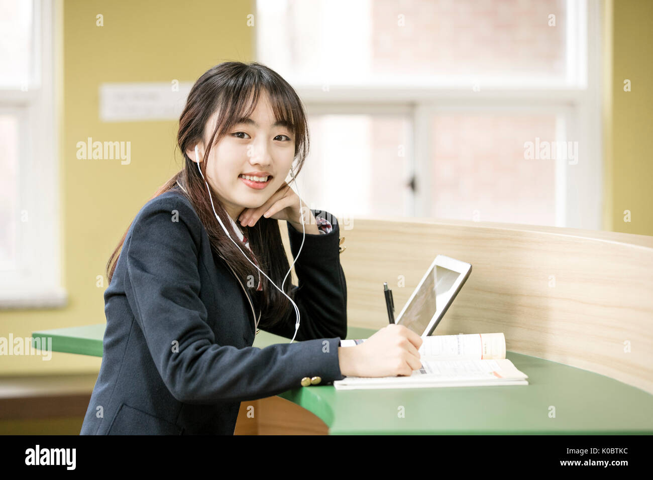 Portrait of smiling school girl studying on tablet Banque D'Images