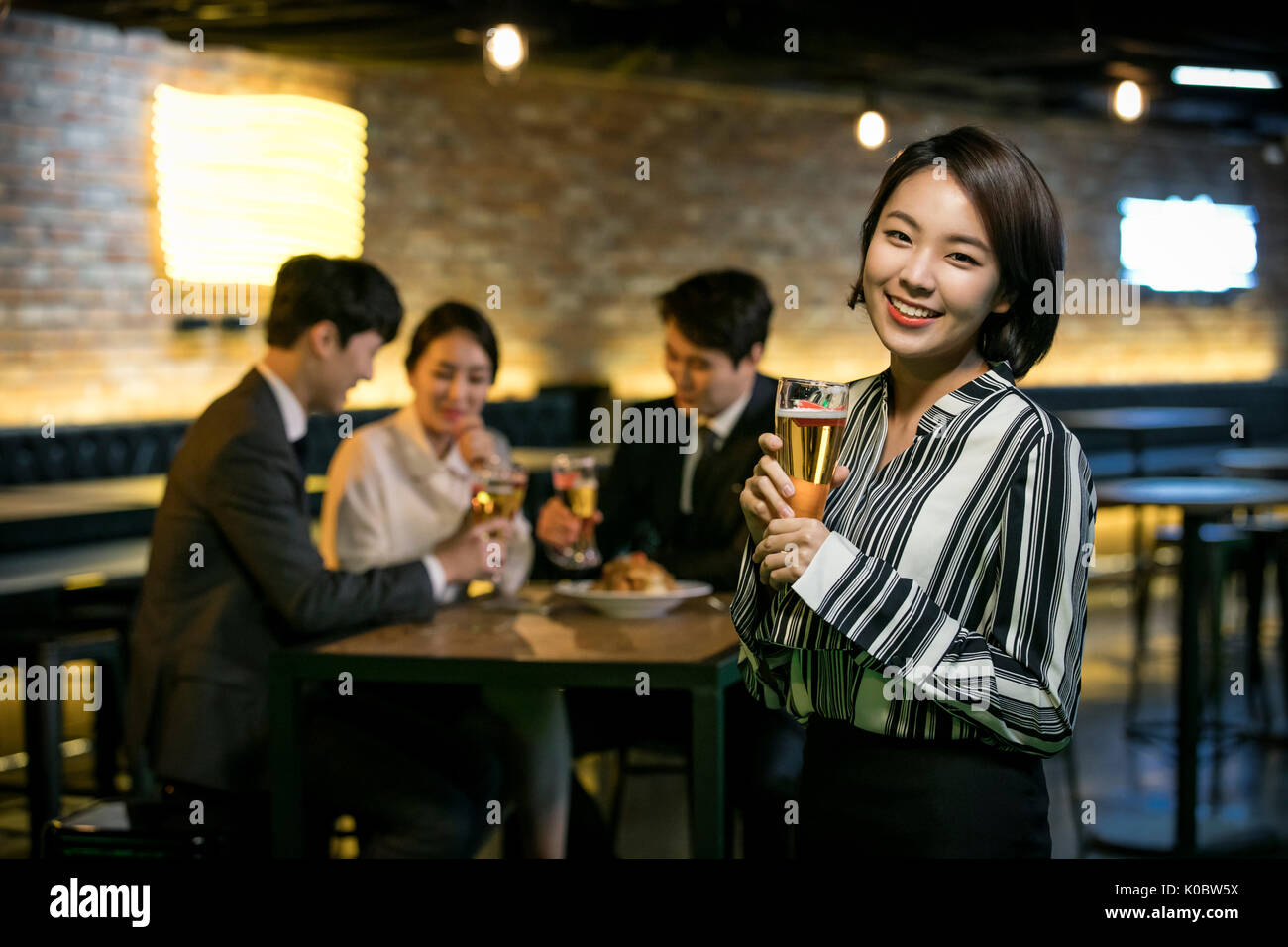 Smiling businesswoman et ses collègues au get-together Banque D'Images