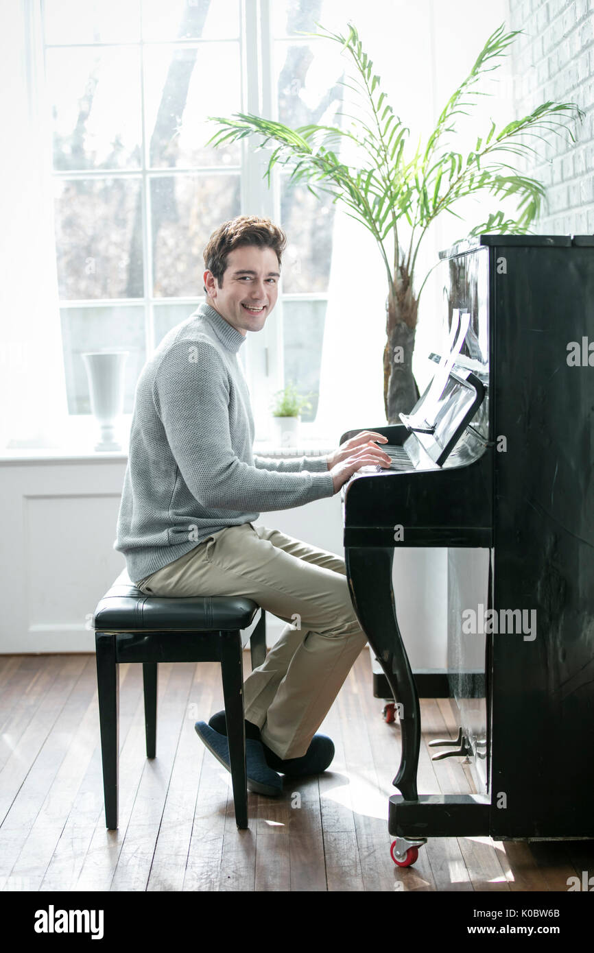 L'homme occidental souriant le piano Banque D'Images