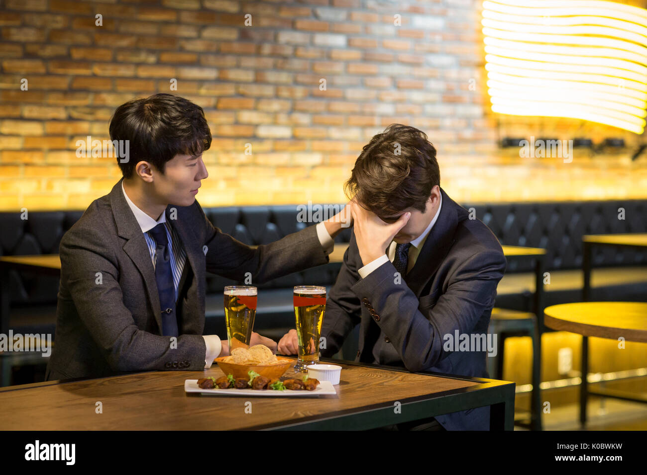Businessman encourageant son collègue de l'alcool au bar Banque D'Images