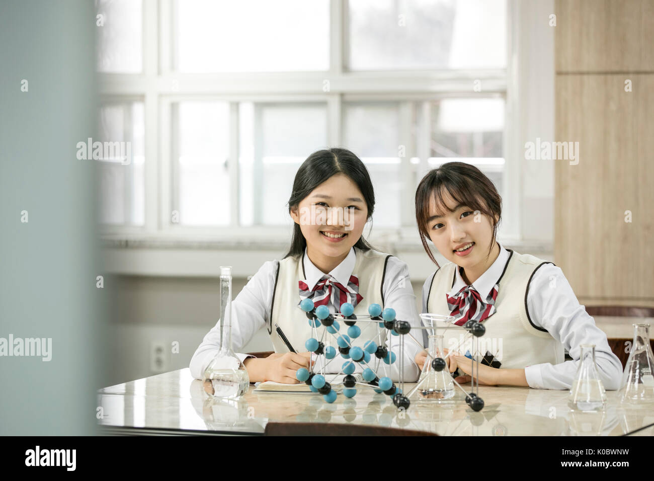 Portrait of smiling deux filles de l'école de prendre la classe de sciences Banque D'Images