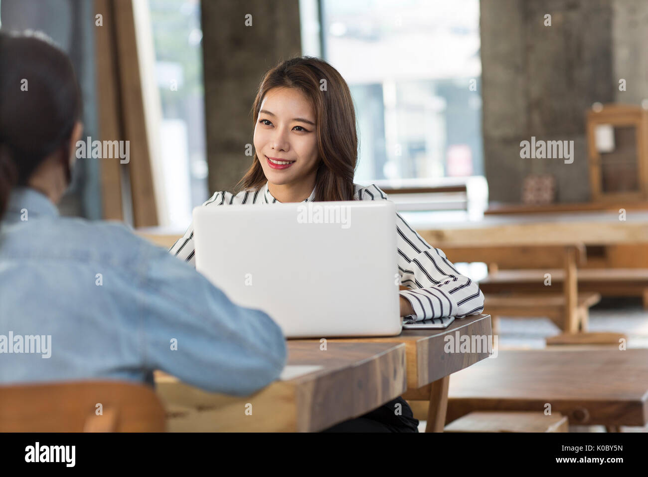 Portrait of smiling businesswoman traitant de client au magasin de meubles Banque D'Images