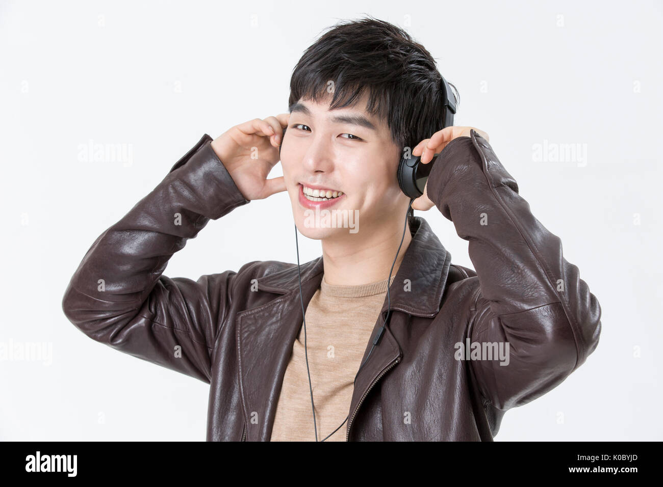 Portrait of young smiling man listening to music Banque D'Images