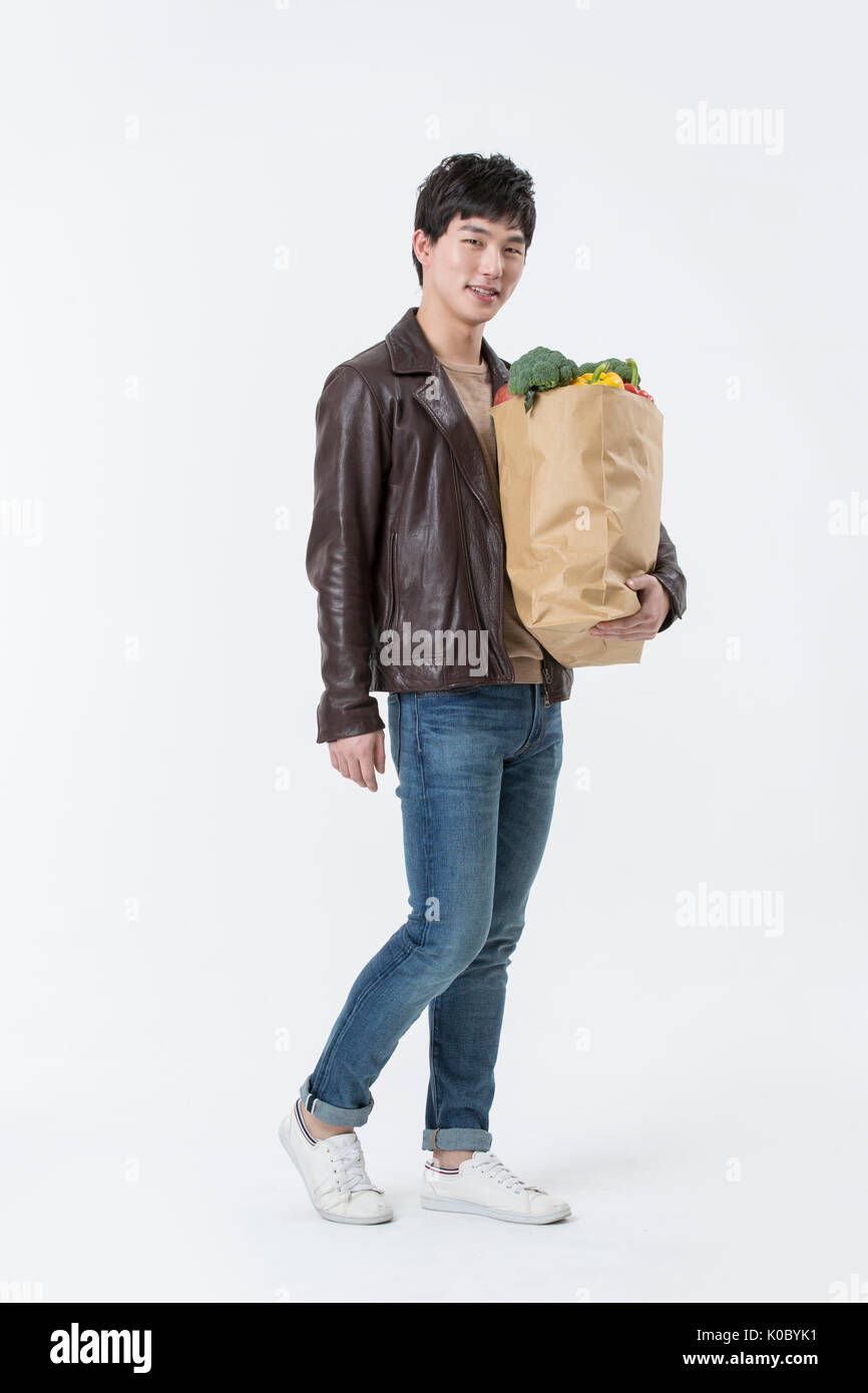 Jeune homme souriant avec panier posing Banque D'Images