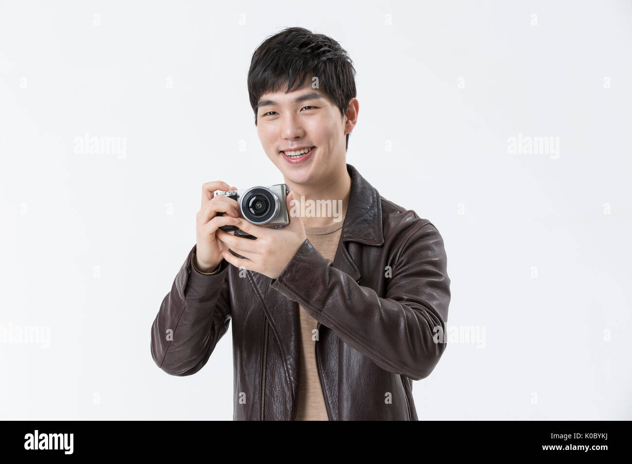 Portrait of young smiling man holding a camera Banque D'Images